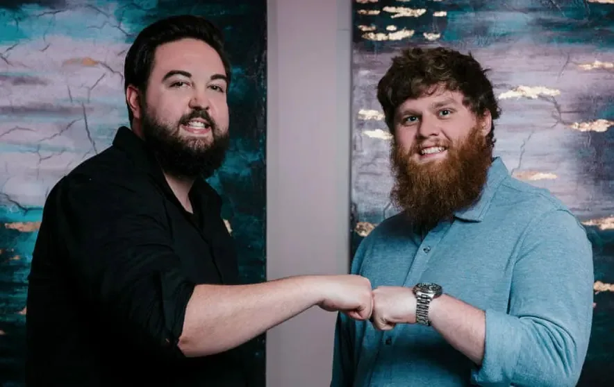 Taylorr and Austin, co-founders of SpeakerFlow, looking straight ahead at the camera and fist bumping.